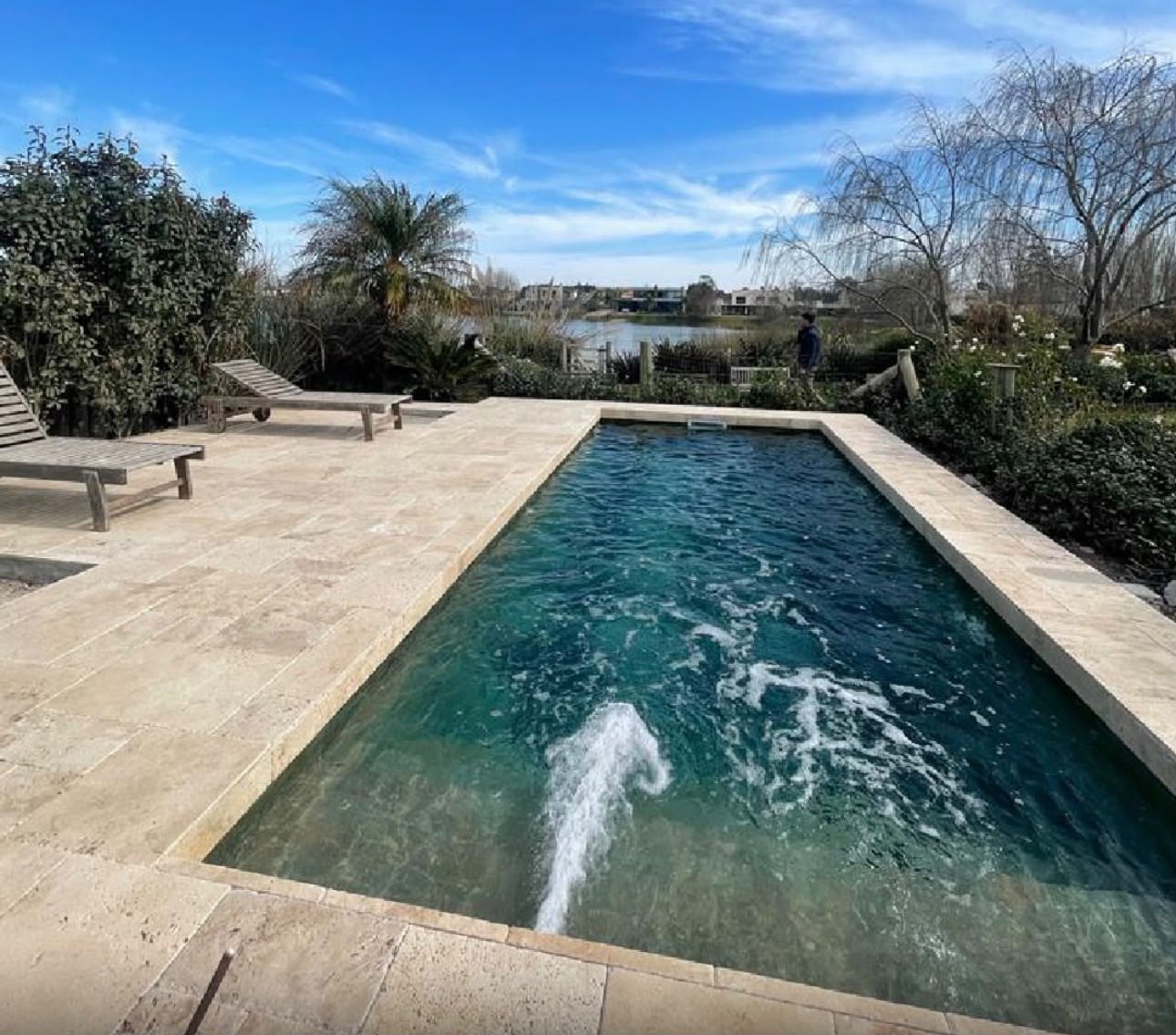 Piscina con solado y jardín